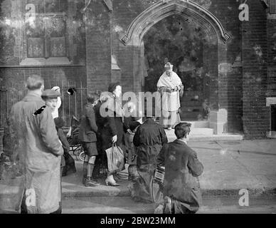 Agenouiller pour recevoir la bénédiction de l'évêque Amigo. Un service spécial à placer dans la cathédrale Saint-Georges, Southwark, pour célébrer le Jubilé en tant que prêtre du Dr Amigo, l'évêque catholique romain de Southwark, âgé de 73 ans. Il est annoncé que le Pape a conféré à M. Amigo la dignité de l'Archevêque, avec le style de l'Archevêque de Southwark. Des séances photos, des membres du public qui ont besoin de recevoir la bénédiction de l'évêque Amigo alors qu'il quittait la Maison de l'évêque, chemin St George, pour le service. 15 février 1938 Banque D'Images