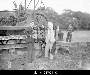 Utilisant un nouveau gyrotimon, une charrue pour creuser, et des hommes travaillant jour et nuit. M. Lloyd George, politicien vétéran qui a maintenant 75 ans, transforme en un temps record 160 acres de terres inutilisées en un jardin de marché. La terre, qui rejoint sa ferme à Churt, Surrey, n'a pas été intensément cultivée depuis de nombreuses années, mais déjà la moitié de la superficie est prête pour la plantation. Les hommes travaillent la nuit par projecteur. Photos: Lloyd George, cheveux blancs balayés par le vent, donnant des instructions à l'opérateur du gyrotimon sur sa nouvelle ferme. 17 octobre 1938 Banque D'Images