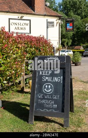 Panneau devant le pub Onslow Arms disant que nous allons continuer à sourire ! Pendant la pandémie du coronavirus Covid-19, Loxwood, West Sussex, Royaume-Uni Banque D'Images