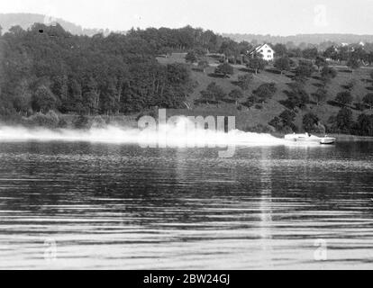 Sir Malcolm Campbell établit un nouveau record mondial de vitesse de l'eau. Sir Malcolm Campbell a établi un nouveau record mondial de vitesse dans son hors-bord « Bluebird » sur le lac Hallwil, près de Lucerne, en Suisse, en couvrant le mile mesuré à une vitesse moyenne pour les deux courses de nos cent et 30.91 miles par heure. Il a précédemment occupé le record du monde avec cent 29.5 miles par heure. Des spectacles photo, « Bluebird » qui survit le lac Hallwill alors que Sir Malcolm Campbell a établi le nouveau record de vitesse. 19 septembre 1938 Banque D'Images