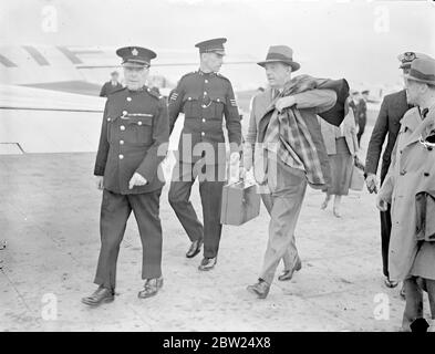 Le capitaine Thomas Kendrick, l'officier britannique de contrôle des passeports à Vienne, qui a été arrêté par la police secrète allemande et accusé d'espionnage, est arrivé à l'aérodrome de Croydon après sa libération. Le capitaine Kendrick a été libéré à condition qu'il quitte l'Allemagne immédiatement. Il est retourné en Angleterre via Budapest et doit faire un rapport personnel au gouvernement britannique sur son arrestation. Expositions de photos, le capitaine Thomas Kendrick, escorté par aérodrome, s'il vous plaît à son arrivée à Croydon. 22 août 1938 Banque D'Images