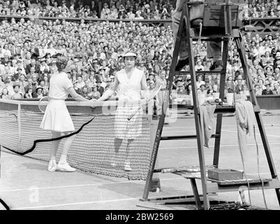 Helen Jacobs se repose après la jambe et laisse place à la finale de Wimbledon. Mlle Helen Jacobs a dû se reposer après que sa jambe ait cédé dans la deuxième série de son jeu d'agaiste de match, Mme Helen W ills Moody dans la finale des célibataires féminins à Wimbledon. Mme Moody a gagné son huitième finale 6-4, 6-0. C'était la quatrième fois qu'ils se rencontraient dans le finsl. Des séances photos, Mme Helen Wills Moody et Mme Helen Jacobs se sont embranchies après leur match. 2 juillet 1938 Banque D'Images