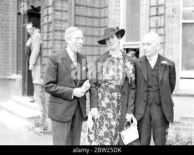 MonoBED George Arliss assiste au mariage de son frère de 70 ans à Londres. George Arlise, l'acteur du film, a assisté au mariage au Hammersmith Register Office, Londres, de son frère âgé de 70 ans, Charles Arliss Andrews, à Mlle Violet Moutrie, qui a cinquante ans. Le mariage suit une amitié familiale qui a commencé il y a de nombreuses années. Expositions de photos, George Arliss, portant son inévitable monocle, avec la mariée sur un marié après le mariage. 4 juillet 1938 Banque D'Images