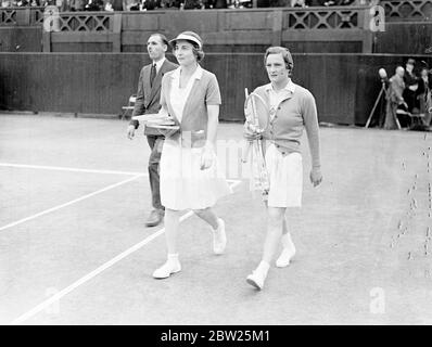 Helen Jacobs se repose après la jambe et laisse place à la finale de Wimbledon. Mlle Helen Jacobs a dû se reposer après que sa jambe ait cédé dans la deuxième série de son jeu d'agaiste de match, Mme Helen W ills Moody dans la finale des célibataires féminins à Wimbledon. Mme Moody a gagné son huitième finale 6-4, 6-0. C'était la quatrième fois qu'ils se rencontraient dans le finsl. Des séances photos, Mme Helen Wills Moody et Mme Helen Jacobs marchant sur le court central. 2 juillet 1938 Banque D'Images