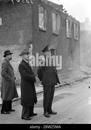 Des maisons royales ont brûlé à Willesden en présence du maire et de la brigade des pompiers. Les maisons d'arrivée, condamnées sous un plan de décharge de taudis a été délibérément mis en feu dans notre place Alpha Nord par la brigade de feu de Willesden. La paraffine et les copeaux de bois ont été utilisés pour démarrer le feu. Le maire de Willesden, Alderman, H R Prothero, et sa fille, Mlle Dilya Prothero (la Mayoress), étaient parmi ceux qui ont regardé le feu. Photos, Alderman H W Prothero, maire de Willesden (pipe à fumer) et surintendant Whitehead, chef de la brigade des pompiers de Willesden, regardant le feu. 4 mai 1938 Banque D'Images