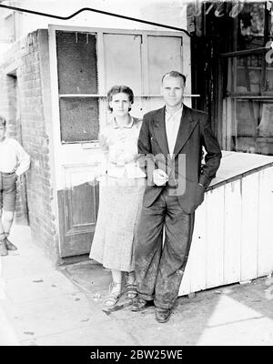 Une femme a poignardé trois fois dans la boutique de Londres, Fishmonger court à son aide. Mme H bols des magasins Handy, New Road, Bermondsey, a été poignardée trois fois par un jeune homme qui a demandé un paquet de thé. Entendre Mme Bowls cries, M. John Flain, le poissonnier voisin, s'est précipité de son lit à son aide. Sur le chemin il a bouleversé son till, dont le bruit a effrayé Mme bols, assailant, qui s'est échappé sur un vélo. Rien n'a été pris. Mme Bowls et son mari ou ses retraités. Photos, M. John Flain et sa femme. Ils ont été les premiers à avoir tendance à la pétanque de Mme après l'attaque. 2 août 1938 Banque D'Images