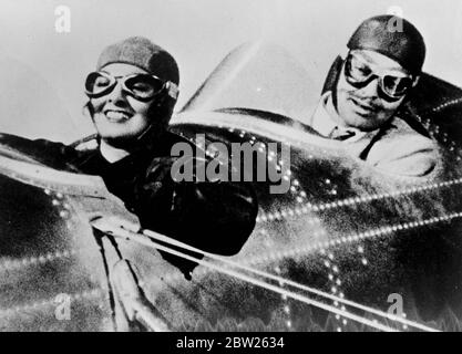 Vaisseau d'audience aérien, à l'étage du studio. Cette série de photos montre le tourbillon d'un tribunal dans le cockpit d'un avion de Myrna Loy et Clark Gable, le daredevil pilote, se présente à Myrna Loy , quand il a forcé des terres est avion dans un champ. L'avion est censé être un mile haut comme Gable donne une leçon de vol à Myrna Loy, mais les prises de vue ont été faites dans une machine spéciale sur le studio. Expositions de photos, Clark Gable, le pilote d'essai de daredevil regarde complaisamment tandis que son 'élève', Myrna Loy met l'avion dans une plongée de puissance. Banque D'Images