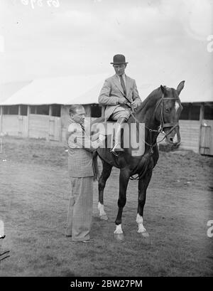 Jack Payne termine au salon Hatfield. Jack Payne, le chef du groupe de danse, est entré dans son cheval 'Odd SOCKS' dans le saut ouvert au salon agricole de Hertfordshire, qui s'est tenu à Hatfield Park, Hertfordshire. Photo shows, Jack Payne, serrant la circonférence de son entrée 'Odd SOCKS' qui est monté par Tom Masson 23 juin 1937 Banque D'Images