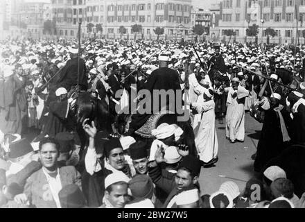 Les Bédouins dansent dans les rues du Caire alors que le roi Farouk est marié. Avec une cérémonie musulmane traditionnelle, le roi Farouk d'Égypte, âgé de 17 ans, s'est marié au palais de Koubbeh au Caire, à Mlle Farida Zulfichar Pasha, juge de la cour d'appel égyptienne. Des spectacles de photos, Bédouins, qui venait du désert pour participer aux célébrations, danser, près du palais Abdin au Caire, au moment de la cérémonie de mariage. 23 janvier 1938. Banque D'Images