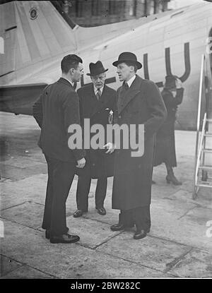 Le chef de précaution des raids aériens du bureau à domicile vole pour Berlin. M. Geoffrey Lloyd, sous-secrétaire parlementaire du Home Office, où il est chef du travail de précautions en matière de raid aérien, a quitté l'aérodrome de Croydon par air pour Berlin, où il doit étudier la méthode de précautions en matière de RAID aérien privilégiée par les autorités allemandes. Il se rendit ensuite à Paris, où il va étudier le système français à la clôture. Séances photo, M. Geoffrey Lloyd (à droite) discutant à l'aérodrome de Croydon, avec le major Fraser du département des précautions contre les aides à la navigation aérienne (au centre) au départ. 18 janvier 1938 Banque D'Images