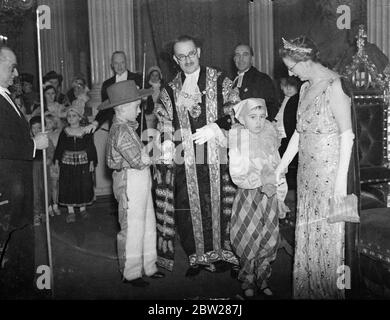 Lord et Lady Mayoress ont reçu des invités sous caution pour enfants. Plus de 1000 enfants déguisent une robe de fantaisie avec un invité du maire de Londres, Sir Harry Twyford, et de la Lady Mayoress, à un bal au Mansion House, Londres. Spectacles photo, le maire et la maï-maï , recevant les invités à la maison de maître. 6 janvier 1938 Banque D'Images