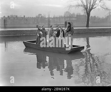 Les équipes de course de bateaux de Cambridge prennent le ferry pour s'entraîner. Quatre mois avant la course en bateau le 2 avril, les équipages de Cambridge ont commencé un entraînement sérieux sur la River Cam à Cambridge, où ils s'exerteront jusqu'en mars, avant de déménager sur la Tamise. Expositions de photos, Cambridge oarsman traversant la Cam en ferry pour la pratique. 5 janvier 1938 Banque D'Images