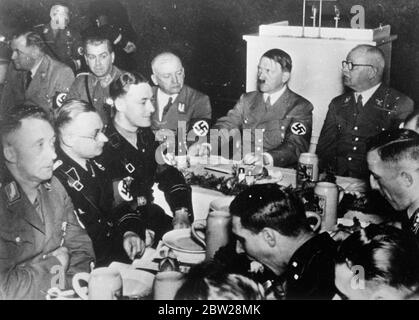 Hitler à la fête de Noël avec "vieux camarade". Hitler a présidé la fête de Noël dans la brasserie Lowenbrau de Munich, en présence des anciens combattants nazis du putsch de 1923. Des séances de photos, le chancelier Hitler préside la fête. A gauche d'Hitler, se trouve le chef de district Adolf Wagner, et l'extrême gauche est sur le chef de groupe Bruckner. Le droit d'Hitler est le maître du Trésor de Reich Schwarz. 27 décembre 1937 Banque D'Images