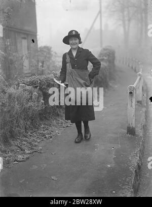 Une femme marchant bureau de poste dans Kent. Mlle Grace Coles, de Wrotham, Kent, est une postaliste auxiliaire et un bureau de poste itinérant. Elle a parcouru des kilomètres chaque jour pour livrer des lettres aux personnes vivant dans des régions éloignées de North Kent Downs, et vend également des timbres et des commandes postales sur elle et clique sur des lettres et des colis de maisons. Son tour commence sur le chemin du pèlerin et se termine à Labor à vain Hill. Elle marche plus de 2500 miles par an. Des spectacles photo, Mlle Grace Coles sur son tour. 7 décembre 1937 Banque D'Images