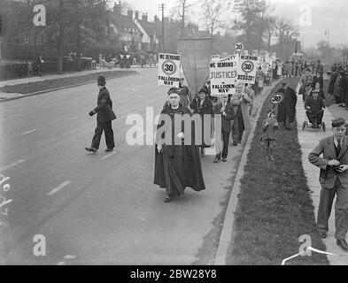 Vicar dirige une réunion de protestation pour la limitation de vitesse sur Falloden Way. Pour protester encore contre la limite de vitesse de 30 miles par heure le long de la route de Falloden, l'une des rues commerçantes les plus fréquentées de Hampstead, le Vicaire de l'église de St Jude, le Rév WH Maxwell Rennie, a mené une procession des propriétaires le long de la section contestée de la route. Le Rév Maxwell Rennie a également adressé un appel écrit au Dr Burgin, ministre des transports. Photos, le Vicaire, le Rév WH Maxwell Rennie, qui mène la procession le long de la route de Falloden. 30 octobre 1937 Banque D'Images