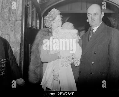 Bébé fils de femme romancier baptisé à l'église de la ville. Où les parents étaient mariés. Le fils de Mme Hugh McCorquodale (Barbara Cartland, romancière) a été baptisé à St Ethelburga la Vierge, Bishopsgate, sa mère a été mariée l'année dernière. Il y avait six parrains et le bébé, qui portait une robe de baptême de dentelle blanche brodée avec des landes, a reçu le nom à Hamilton. M. et Mme Hugh McCorquodale avec leur bébé, Ian Hamilton, après le baptême. 24 novembre 1937 Banque D'Images