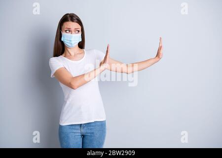 Trop proche. Photo de femme sérieuse garder la distance sociale éviter de peur des personnes de contact lever les bras côté vide espace stand deux mètres d'usure protéger le visage Banque D'Images