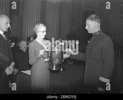 Lady Mayoress remet des prix à la police de la ville de Londres. La Lady Mayoress, Lady Twyford, a remis des prix et des prix pour bravoure à la police de la ville de Londres dans le manoir de Londres. Expositions de photos, la Dame Mayoress, présentant la Mathi Cup pour le tir automatique au pistolet à l'agent de police Waissen. 8 décembre 1937 Banque D'Images