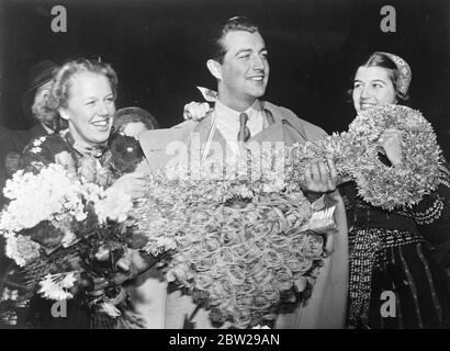 Féminine Suède présente Robert Taylor, avec la clé de son coeur!. Une énorme touche florale et un coeur de fleurs ont été présentés à Robert Taylor, l'acteur du film, par deux filles suédoises lorsqu'il est arrivé à l'aérodrome de Bromma, à Stockholm. Les filles ont été élues pour l'honneur de centaines de candidats. Des spectacles photo, Robert Taylor, recevant la touche florale et le coeur des filles suédoises à l'aérodrome de Bromma, Stockholm. 26 novembre 1937 Banque D'Images