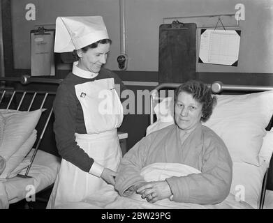 Mère, père et fils à l'hôpital après l'incendie de la maison de Londres, pour blessés. M. Arthur Davies, 41 ans, sa femme, Winifred Davies, 40 ans environ, a été parmi quatre personnes blessées dans un incendie qui a éclaté à la maison de New Church Road, Camberwell, et qui sont maintenant à l'hôpital St Giles, Camberwell. Ivor Davies, leur fils de 11 ans, et Arthur George Bird, âgé d'environ 32 ans, un locataire, ont également été blessés. M. et Mme Davies , autre fils, John Davies, âgé de 15 ans, ont donné l'alarme et ont échappé à la blessure. Photos, Mme Winifred Davies à l'hôpital St Giles, où elle souffre de blessures aux chevilles. 30 décembre 1937 Banque D'Images