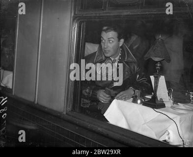 Robert Taylor, au revoir, quitte Londres pour l'Amérique. Robert Taylor, l'acteur américain, qui travaille dans le film britannique 'A Yank at Oxford', a quitté la gare de Waterloo sur le train de bateau 'Queen Mary' pour rentrer chez lui. 8 décembre 1937 Banque D'Images