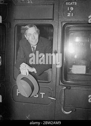 Le MonoBED George Arliss revient à Hollywood. George Arliss, l'acteur du film, avec son monocle, s'inclinant sur le rail du train de bateau 'Aquitania'lorsqu'il quitta Londres à Southampton à son retour à Hollywood. 3 novembre 1937 Banque D'Images