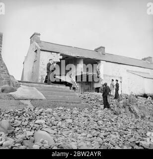 Certains villageois de la menace d'Amreth, sur la côte du Pembrokeshire, au pays de Galles, ont cessé la bataille contre l'Atlantique et ont été forcés de quitter leurs maisons en mer. Dévastés par les marées hautes du printemps, plusieurs chalets faisant face à l'Atlantique ont été épatés et leurs propriétaires contraints de quitter leurs maisons. Les villageois ont renforcé le mur de la mer pour éviter que les vagues ne débordent et ne s'empassent du village. La photo montre des chalets ruinés, avec des masses de galets entachés contre les restes des murs. 6 février 1939 Banque D'Images