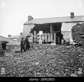 Certains villageois de la menace d'Amreth, sur la côte du Pembrokeshire, au pays de Galles, ont cessé la bataille contre l'Atlantique et ont été forcés de quitter leurs maisons en mer. Dévastés par les marées hautes du printemps, plusieurs chalets faisant face à l'Atlantique ont été épatés et leurs propriétaires contraints de quitter leurs maisons. Les villageois ont renforcé le mur de la mer pour éviter que les vagues ne débordent et ne s'empassent du village. La photo montre des chalets ruinés, avec des masses de galets entachés contre les restes des murs. 6 février 1939 Banque D'Images