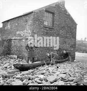 Certains villageois de la menace d'Amreth, sur la côte du Pembrokeshire, au pays de Galles, ont cessé la bataille contre l'Atlantique et ont été forcés de quitter leurs maisons en mer. Dévastés par les marées hautes du printemps, plusieurs chalets faisant face à l'Atlantique ont été épatés et leurs propriétaires contraints de quitter leurs maisons. Les villageois ont renforcé le mur de la mer pour éviter que les vagues ne débordent et ne s'empassent du village. La photo montre des chalets ruinés, avec des masses de galets entachés contre les restes des murs. 6 février 1939 Banque D'Images