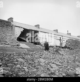 Certains villageois de la menace d'Amreth, sur la côte du Pembrokeshire, au pays de Galles, ont cessé la bataille contre l'Atlantique et ont été forcés de quitter leurs maisons en mer. Dévastés par les marées hautes du printemps, plusieurs chalets faisant face à l'Atlantique ont été épatés et leurs propriétaires contraints de quitter leurs maisons. Les villageois ont renforcé le mur de la mer pour éviter que les vagues ne débordent et ne s'empassent du village. La photo montre des chalets ruinés, avec des masses de galets entachés contre les restes des murs. 6 février 1939 Banque D'Images