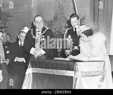 Leurs Majestés le Roi et la Reine signent le Livre d'or des visiteurs à l'Hôtel de ville, Montéal On voit aussi le maire Houde. 27 mai 1939 Banque D'Images