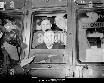 L'équipe d'essai du MCC pour visiter l'Afrique du Sud a quitté la gare de Waterloo sur le train de bateaux du château d'Athlene. Spectacles photo: Len Hutton (à gauche), batteur du Yorkshire, avec Paynter (Lancashire), centre, et WJ (Bill) Edrich de Middlesex dans leur fenêtre de calèche à Waterloo. 21 octobre 1938 Banque D'Images