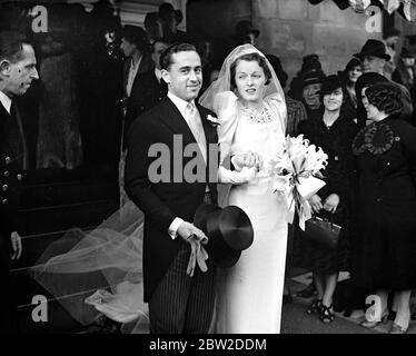 Portant une robe de mariée d'argent blanc avec le train renforcé de colle par un vieux processus oriental, Mlle Elizabeth Fletcher a été mariée à l'Oratoire de Brompton, à Londres, à l'honorable David Fielding, frère du vicomte Feilding. Le marié est petit-fils de Lord Denbigh. Spectacles photo: La mariée et le marié partant après le mariage. 19 octobre 1938 Banque D'Images