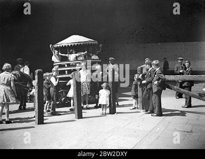 Enfants jouant sur un rond-point mobile. 1933 Banque D'Images