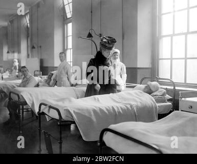 Visite royale aux héros blessés de Zeebrugge à l'hôpital naval de Chatham. La Reine parle à A.B. John Rose de la vindicative. 30 avril 1918 Banque D'Images