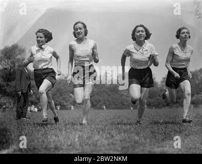 Filles athlètes entraînement du dimanche pour les jeux du monde . Les filles athlètes du London Olmpiades Club ont passé dimanche au soleil sur le circuit de Battersea Park , l'entraînement pour les Jeux mondiaux de cette année . De droite à gauche - Mlle F Tapner , Mlle F Moore , Mlle M Menzies et Mlle C Burrell , à l'entraînement au sprint à Battersea Park , Londres . 13 mai 1934 Banque D'Images