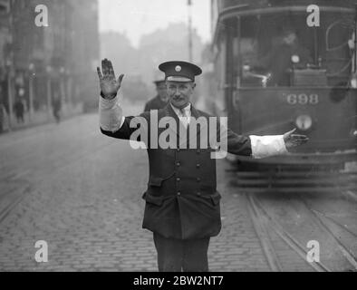 Inspecteurs de tram blancs armés comme assistants de police à Londres , nouveau déménagement de sécurité de rue . Des armulets blancs ont été délivrés aux inspecteurs et aux régulateurs des tramways du Conseil du comté de London pour les utiliser dans le contrôle du trafic en collaboration avec la police . C'est le dernier effort en rapport avec la sécurité de la rue . Un des nouveaux régulateurs de tramway blanc à talons aiguilles en service aidant un policier à St Georges Circus , Londres . 25 septembre 1931 Banque D'Images