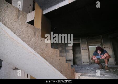 Jeune homme prenant la photo sur l'escalier d'un bâtiment abandonné en ruines Banque D'Images