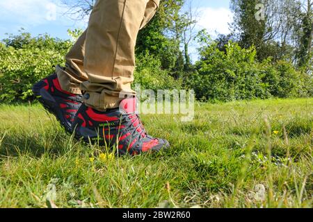 Homme jambes marchant à l'extérieur avec une paire de Merrell Red Accenteur Sport GORE-TEX Trail Chaussures Banque D'Images