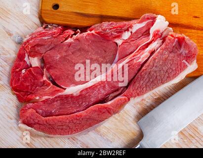 Steak de bœuf frais cru sur fond de bois avec herbes Banque D'Images