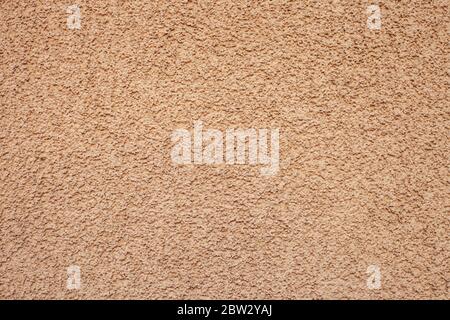 Façade en stuc à trait de galets jaune texturé. Mur de maison finition orange motif extérieur en plâtre. Toile de fond brute abstraite de couleur claire Banque D'Images