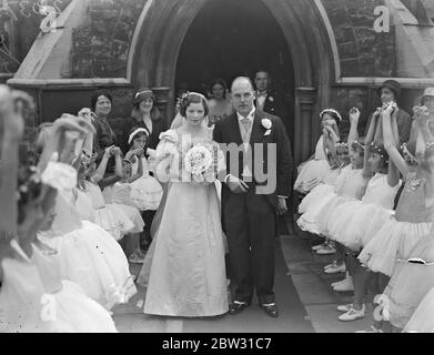 Garde d'honneur de la mariée des danseurs de ballet . Champion danseuse de salle de bal se dévêque dans trente-deux ans robe de mariage. Vêtu d'une robe de mariage trente-deux ans, Portée par sa mère de demoiselles d'honneur lors de son mariage, Mlle Gladys Fraser , la célèbre championne de danse de salle de bal a été mariée à l'église St Stephens , Gloucester Road , Londres , à M. W E H Thomas de Manchester . La mariée a récemment remporté le championnat de l'Ouest de l'Ecosse . La mariée et le marié quittant l'église par une garde d'honneur de petits danseurs de ballet . Mlle Irene Ashton, danseuse de ballet , était la demoiselle d'honneur en chef . 31 août Banque D'Images