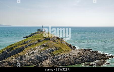 Mumbles Lighthouse au large de la côte entre Mumbles et Bracelet Bay Swansea. Banque D'Images