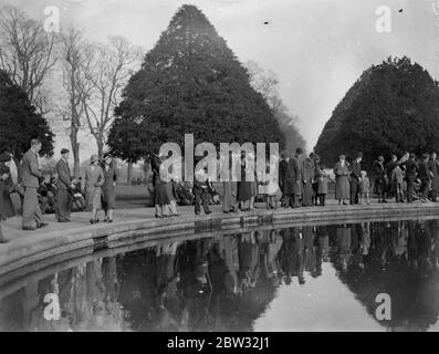 Le dimanche, la foule à Hampton court. Le soleil éclatant du premier dimanche de printemps a attiré un grand nombre de visiteurs au palais de Hampton court . La foule au Hampton court Palace à côté de l'étang aux nénuphars. 20 mars 1932 . Banque D'Images