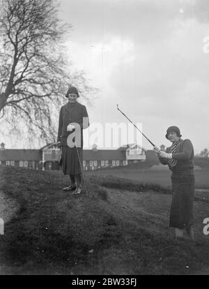 Le tournoi de golf parlementaire Dames ouvre à Ranelagh . L'association Ladies Parliamentary Golf a organisé un tournoi d'invitation au Ranelagh Club , Londres pour célébrer le 21 anniversaire de l'association , de nombreuses femmes golfeurs des cercles parlementaires y ont participé . Lady Droghoda en sortant d'un bunker surveillé par Mme Robert Fleming . 8 avril 1932 . Banque D'Images