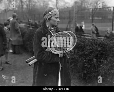 Nouvelle mode en articles de chapellerie de tennis . Mlle J Mc Alpine joue avec la montre en bandou . Mlle J Mc Alpine , a mis une nouvelle mode en coiffures de tennis , lorsqu'elle a joué dans le West Side Country Club Tournament avec une montre fixée dans son bandou . Mlle J Mc Alpine avec sa montre dans son bandou regardant le jeu au tournoi . 18 avril 1932 Banque D'Images