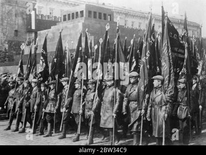 La Russie célèbre le jour de mai avec le plus grand affichage militaire des années . La Russie a célébré le jour de mai avec la plus grande exposition militaire de Moscou , des milliers de troupes et de civils armés qui ont déposé devant la tombe de Lénine , tandis que 275 avions ont effectué des manœuvres aériennes . Le salut a été pris par Joseph Staline de la plinthe du tombeau . Bannières portées par les travailleurs marchant dans la procession à travers la place Rouge , Moscou . 4 mai 1932 Banque D'Images