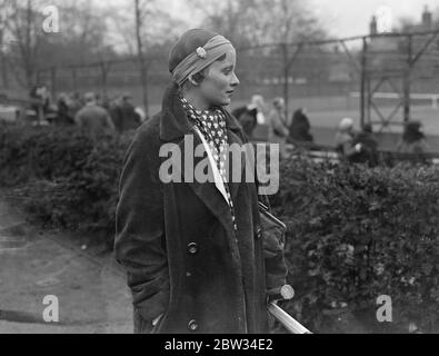 Nouvelle mode en articles de chapellerie de tennis . Mlle J Mc Alpine joue avec la montre en bandou . Mlle J Mc Alpine , a mis une nouvelle mode en coiffures de tennis , lorsqu'elle a joué dans le West Side Country Club Tournament avec une montre fixée dans son bandou . Mlle J Mc Alpine avec sa montre dans son bandou regardant le jeu au tournoi . 18 avril 1932 Banque D'Images