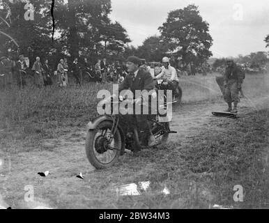 Surf board équitation derrière les motos au-dessus du sol , Britains dernier sport . Surf board cheval derrière des motos sur une piste d'herbe est le dernier sport en Grande-Bretagne . La course de surf est de plus en plus mise en scène à des rencontres sportives dans tout le pays et fournit un grand frisson pour les spectateurs et les cavaliers comme les motos vitesse au sol attirant leurs cavaliers . Les déversements sont fréquents . Une fille de surf pilote gagnant une course au Wembley Speedway sports Motor club réunion à Hillingdon , près de Uxbridge . 26 juin 1932 Banque D'Images