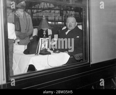 Un fonctionnaire britannique a prêté au Canada pour lancer un nouveau service de radiodiffusion . Le major Gladstone Murray de la British Broadcasting Company , est parti pour le Canada à bord de la SS Majestic pour conseiller la Commission de radiodiffusion canadienne sur l'organisation d'un service national de radiodiffusion pour le Canada . Il a été prêté au Canada à la demande de M. Pennet, Premier ministre du Canada . Le major Gladstone Murray assis à la table du train au départ de Waterloo pour Southampton . 15 mars 1933 Banque D'Images